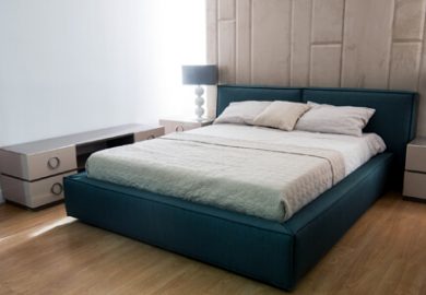 Hybrid mattress on bed frame in room.